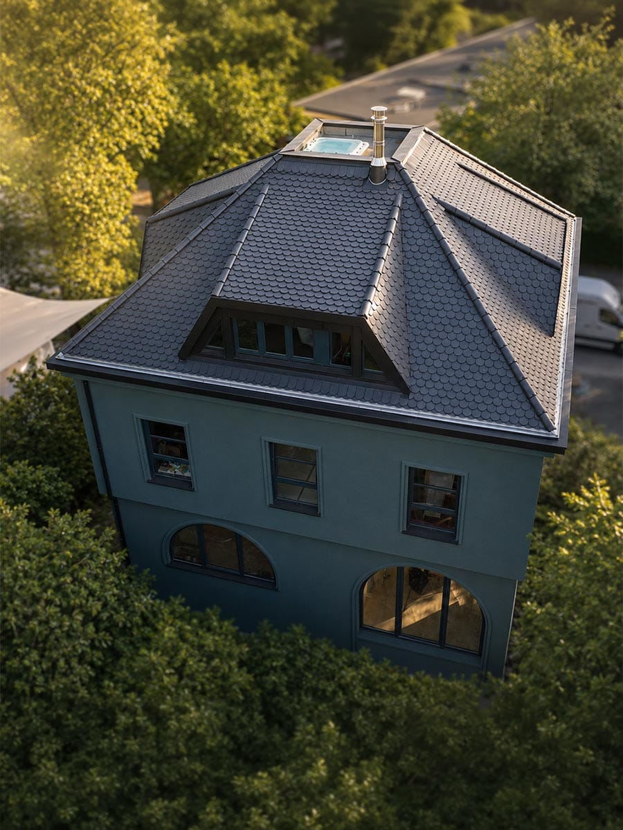 Einzelnes Haus aus Vogelperspektive mit grauem Dach und großen Fenstern